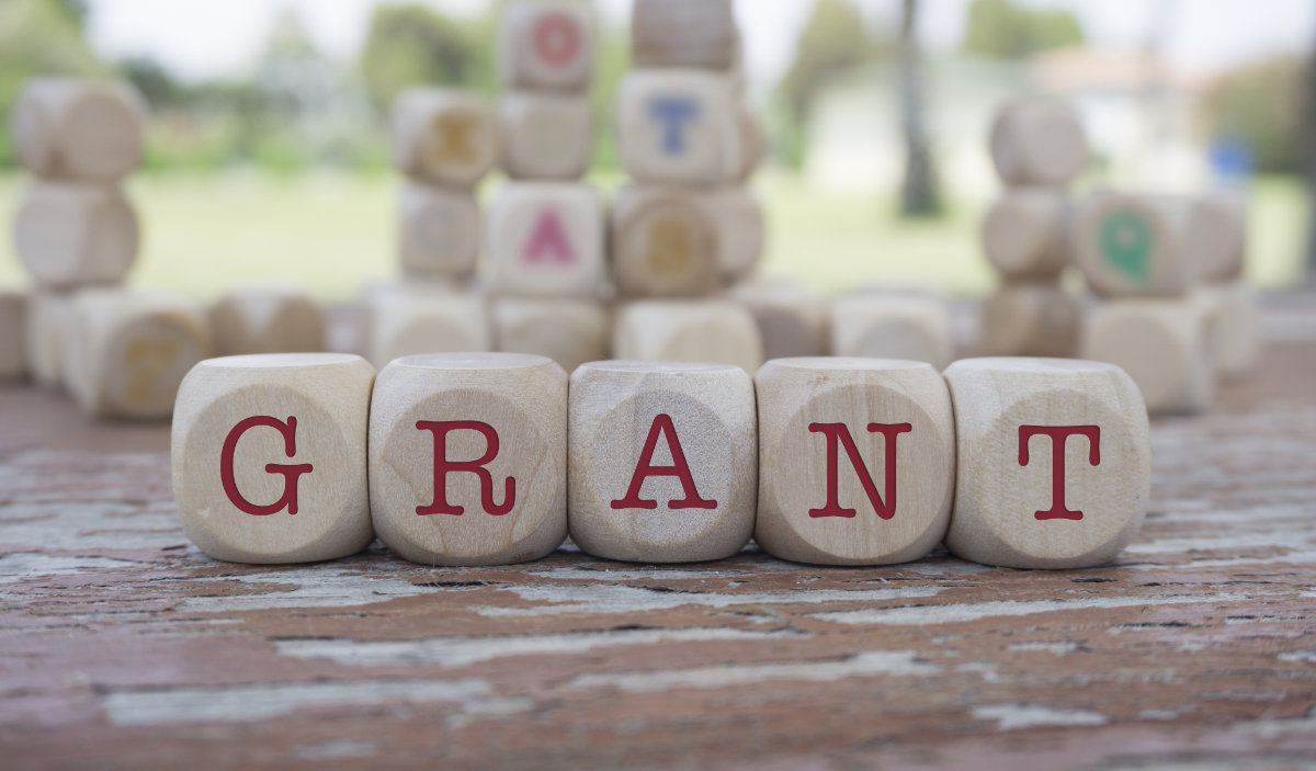 grant word written on cube shape wooden blocks on wooden table.