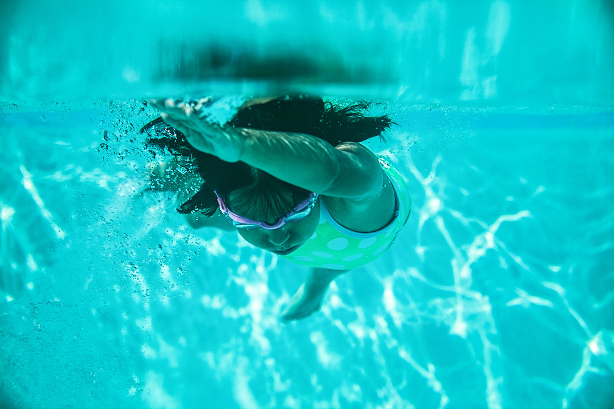 little girl swimming seen from underwater